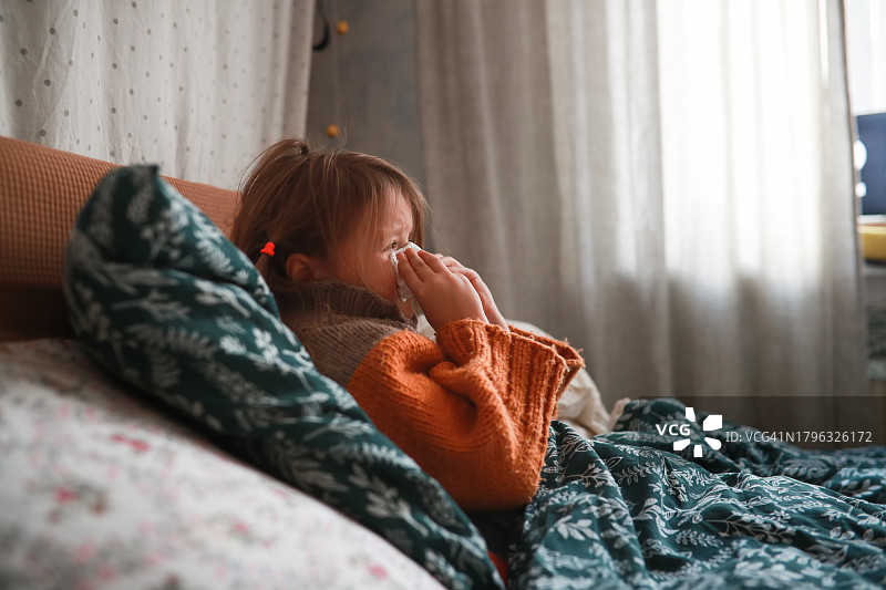 季节性流鼻涕：毛衣儿童裹着毯子对抗季节性寒冷图片素材