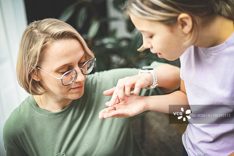 女儿向妈妈展示掉落的牙齿图片素材