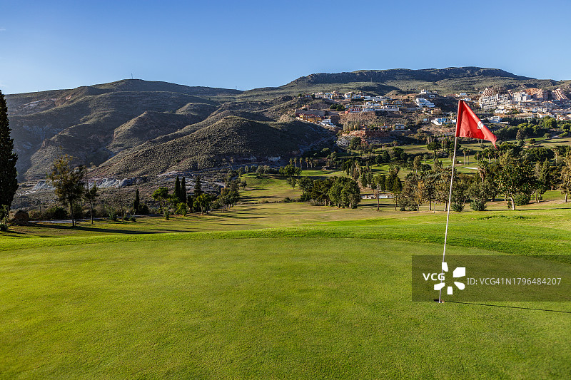 高尔夫球场全景，前景为一片绿地。图片素材