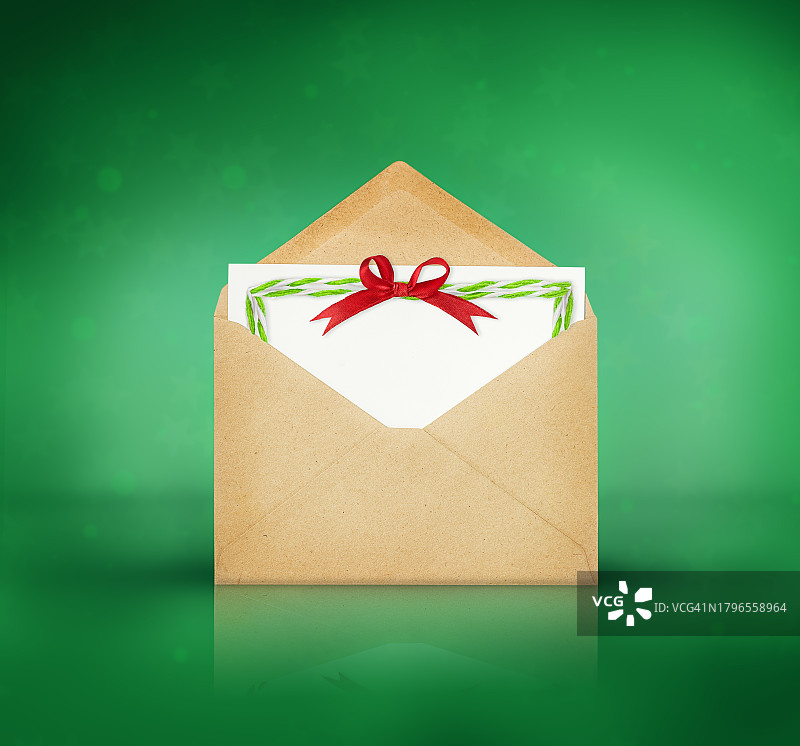 绿色背景上的带祝贺语的棕色信封图片素材