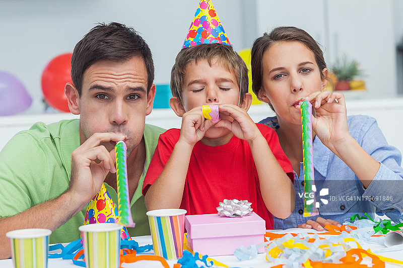 幸福的一家人吹着派对喇叭图片素材