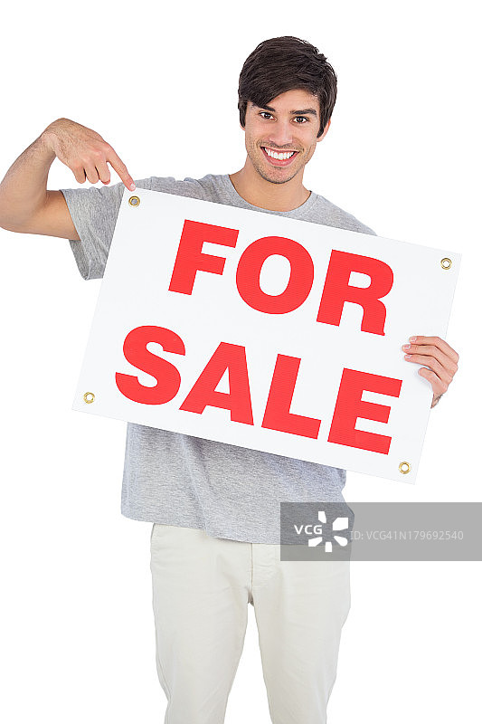 微笑的男人指着出售标志图片素材
