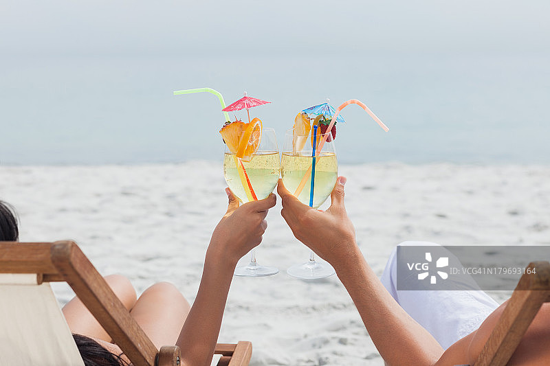 情侣在海滩上碰鸡尾酒杯图片素材