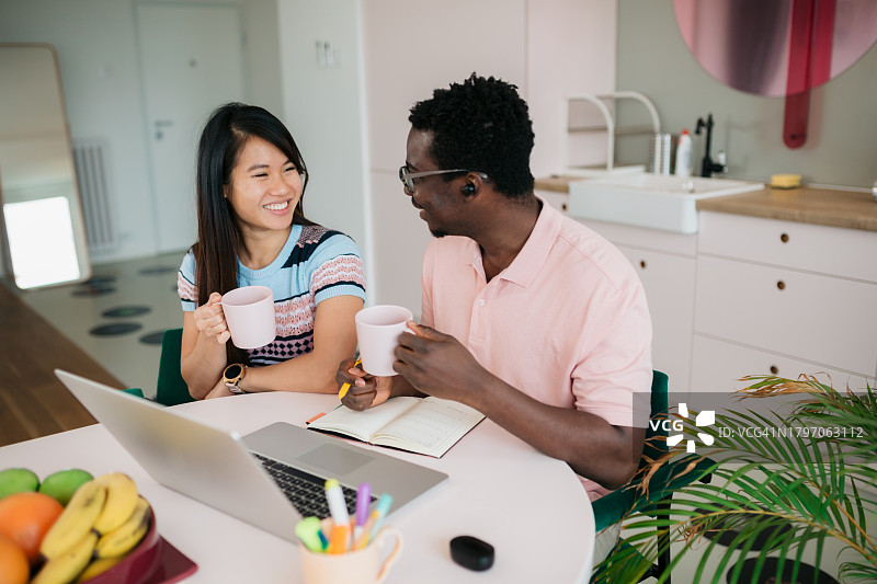 多种族商业同事在家一起工作时喝咖啡休息图片素材