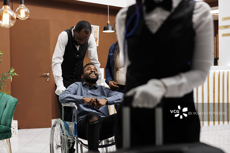 坐在轮椅上的男人在商店里为女顾客服务图片素材