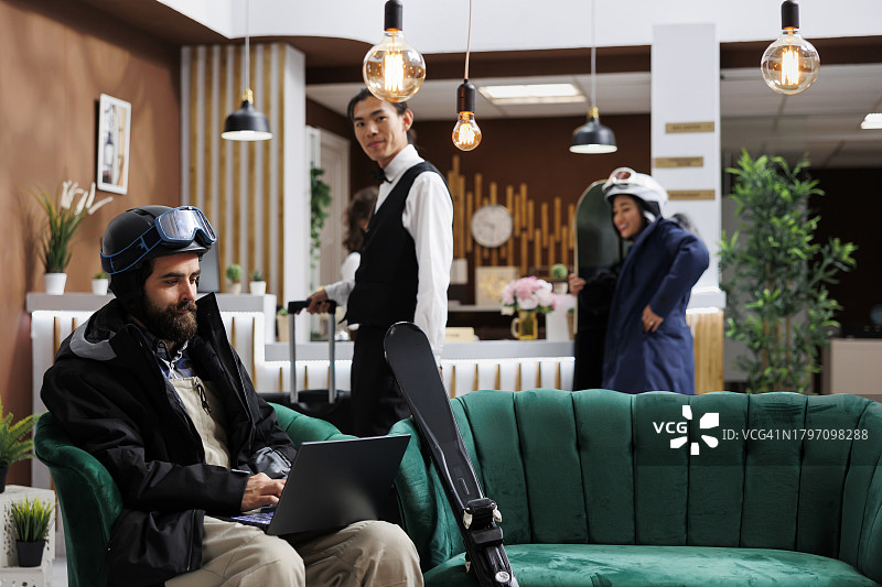 在酒店休息室使用笔记本电脑的男人图片素材