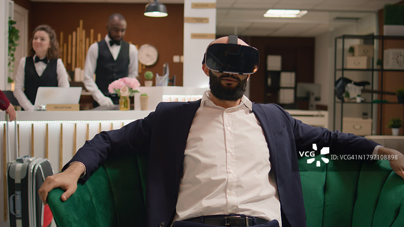 在沙发上使用VR眼镜的经理图片素材