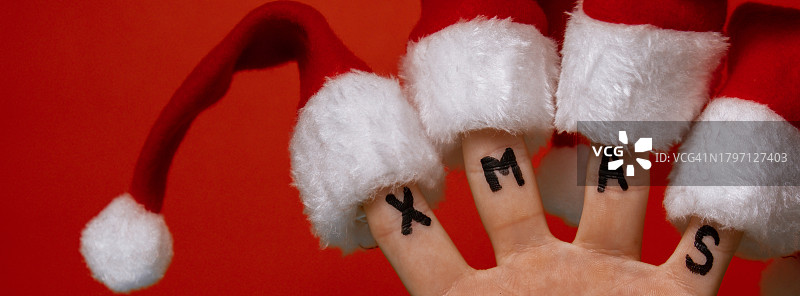 红色背景：手持戴圣诞帽的圣诞老人图片素材