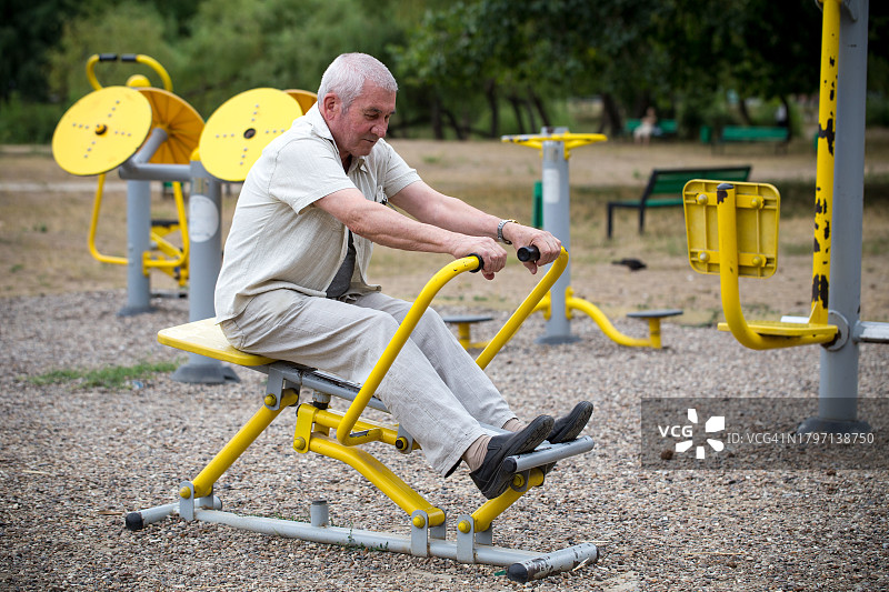 在户外健身房锻炼的年长男人侧视图图片素材