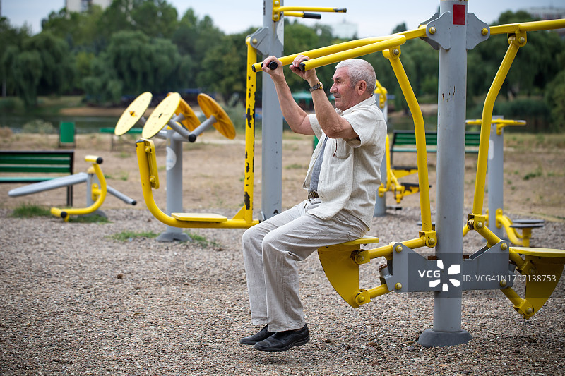 在户外健身房锻炼的年长男人侧视图图片素材