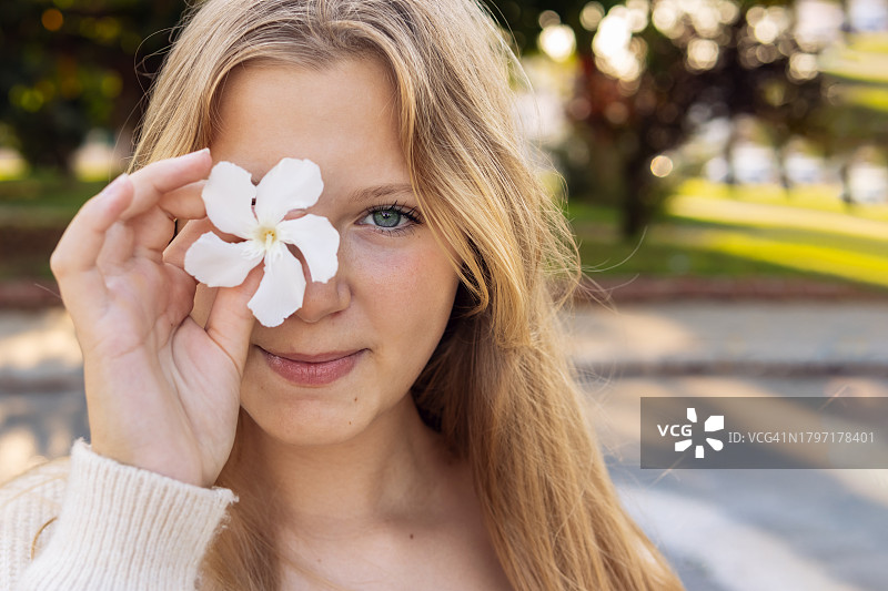 在公园里手捧鲜花的微笑女孩特写图片素材