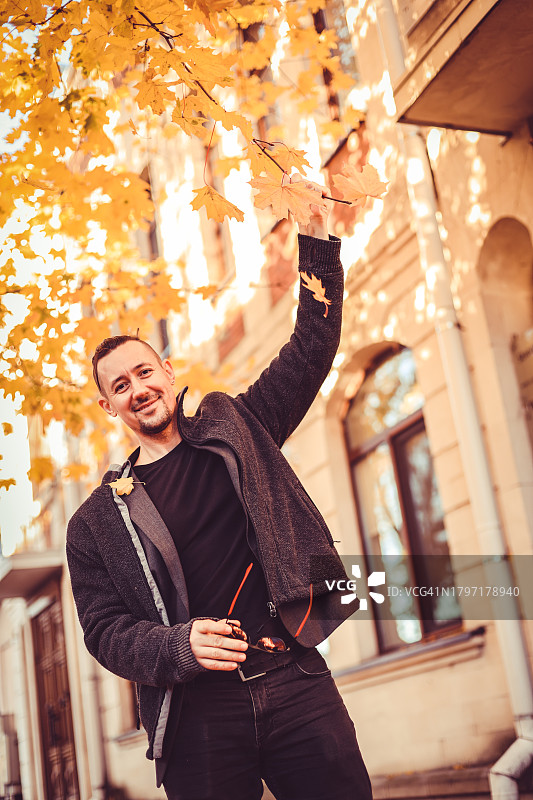 秋天站在树旁的微笑男人 портрет图片素材