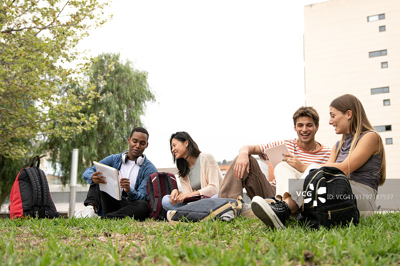 坐在外面阅读文件的学生们图片素材
