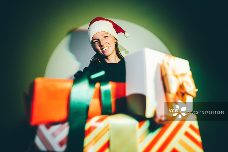 戴圣诞帽、手持圣诞礼物的滑稽女人图片素材