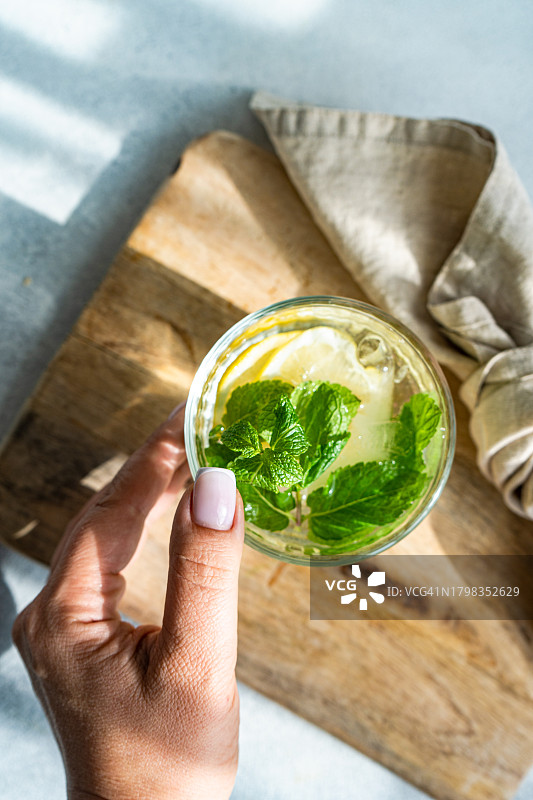 个人视角：女人伸手拿薄荷柠檬水图片素材
