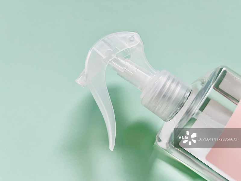 塑料喷雾瓶顶部特写（绿色背景）图片素材