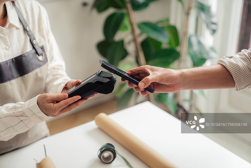 在植物店售卖鲜花的女人图片素材