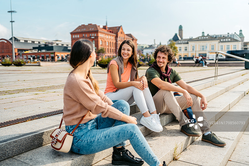 在瑞典马尔默街头台阶上休息的三位年轻人图片素材