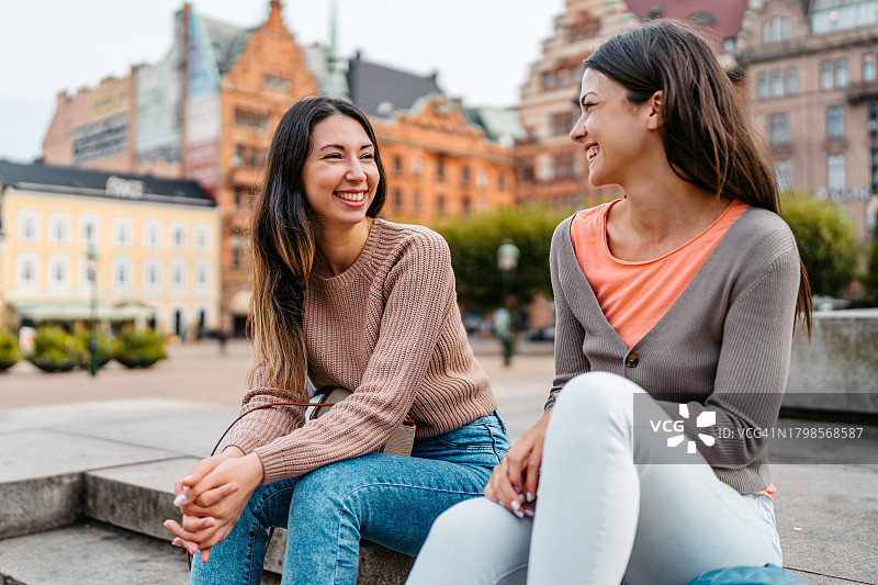 两位女性朋友坐在瑞典马尔默斯托尔托格广场的台阶上图片素材