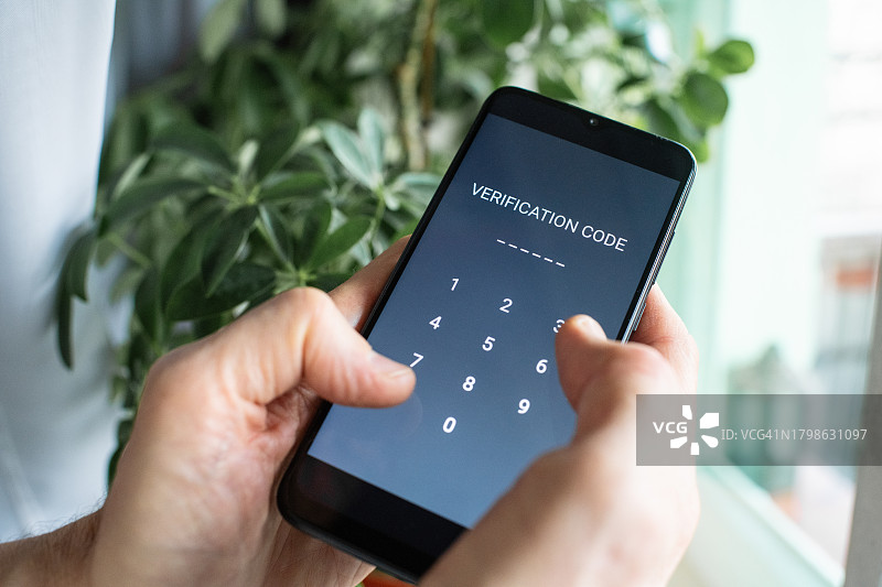 严重的老年男子在家输入智能手机的验证码，防止欺诈的概念。图片素材