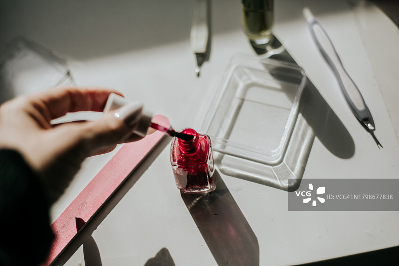 人手涂抹红色指甲油图片素材