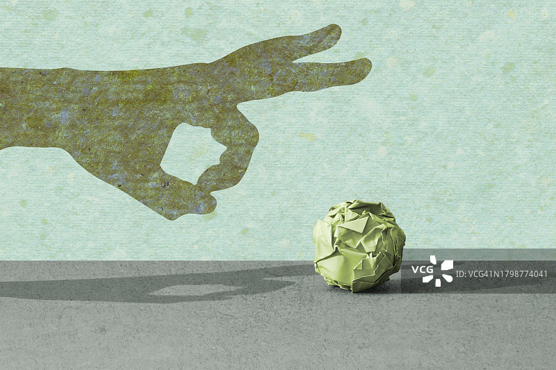 一只手弹起一个揉皱的纸团图片素材