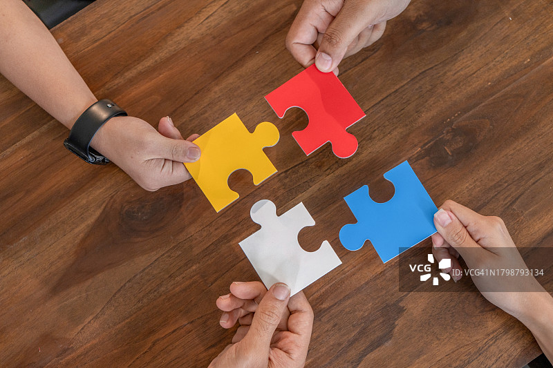 团队合作概念：办公室里手拼拼图图片素材