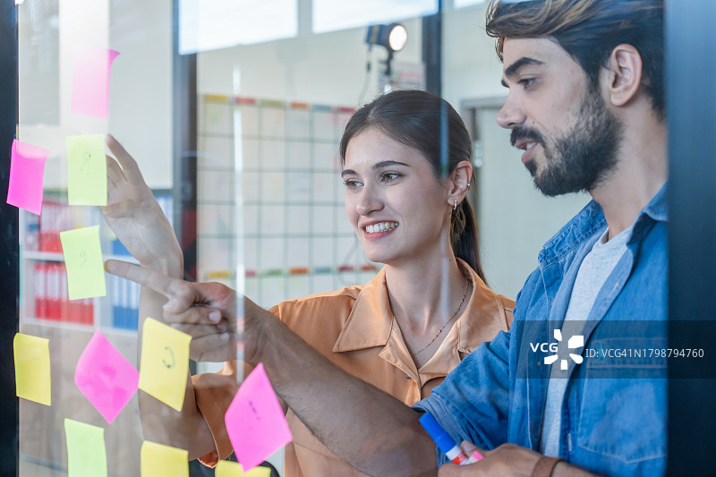 商务人士讨论并在便签上写笔记图片素材