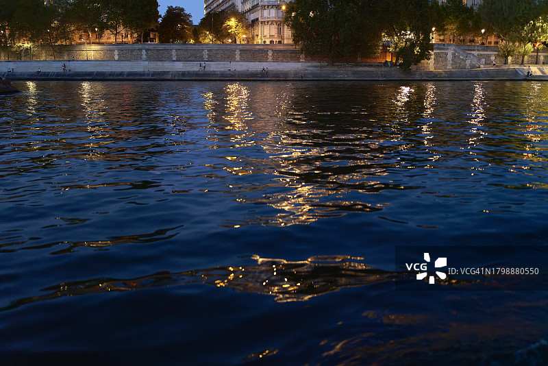 夜晚塞纳河的宁静，城市灯光倒映在水中，法国巴黎图片素材