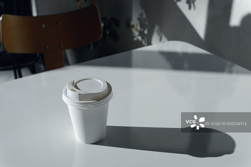 时尚咖啡馆白色桌子上的外带热咖啡或茶一次性杯子图片素材