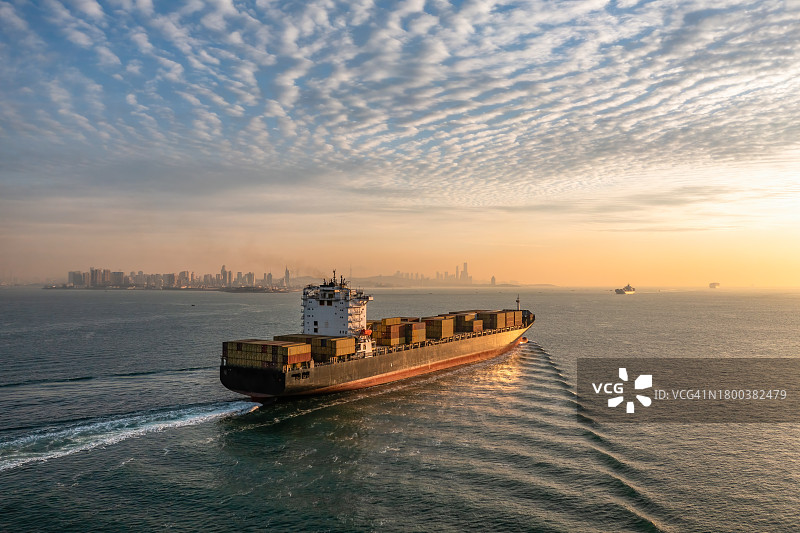 一艘货船在晨光中航行在海上图片素材