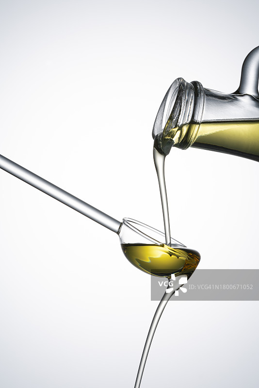油瓶将橄榄油倒入玻璃勺中图片素材
