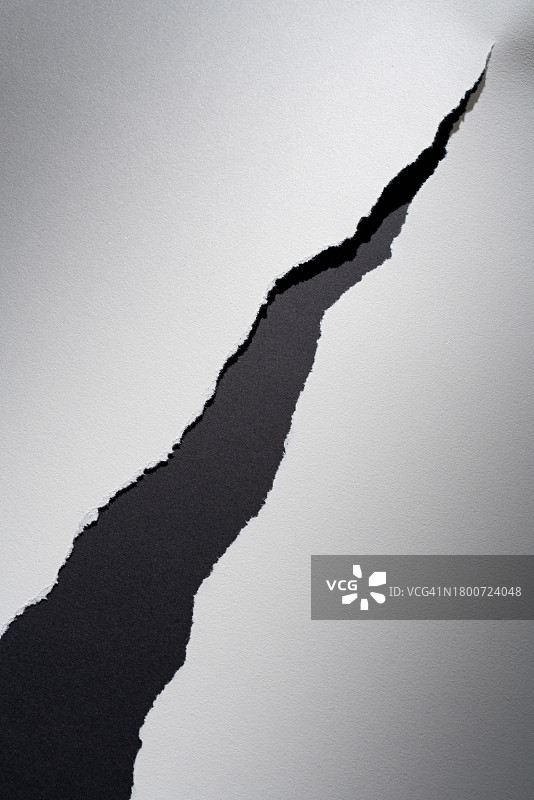 黑色背景上的撕裂白纸图片素材