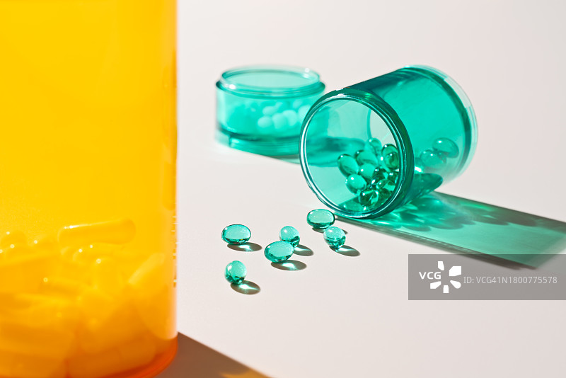 药瓶中洒落的绿色软胶囊图片素材