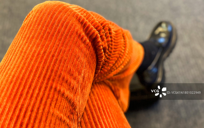 穿着灯芯绒裤子的女人的交叉双腿图片素材