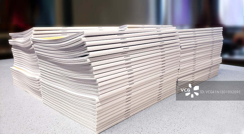 白色柜台上堆叠的白色宣传册图片素材