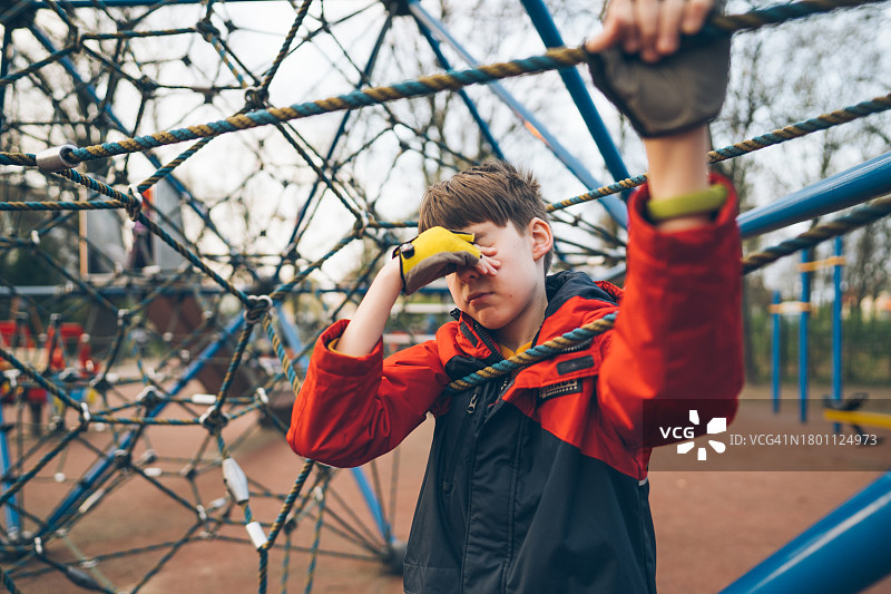 游乐场上疲惫的青少年用手捂着脸图片素材