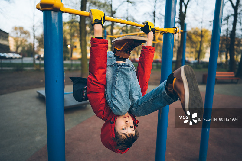 男孩倒挂在单杠上图片素材