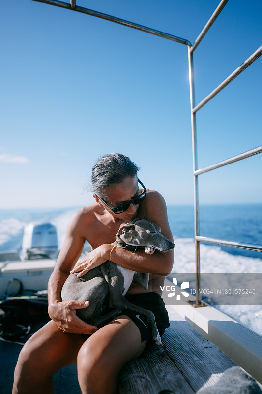 男人在船上亲吻他的狗图片素材