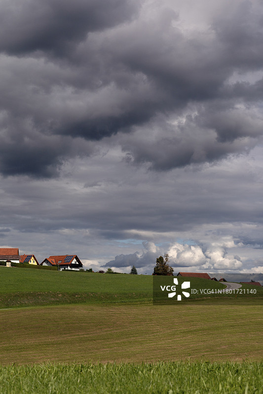 黑云下山丘田野中的村庄景色图片素材