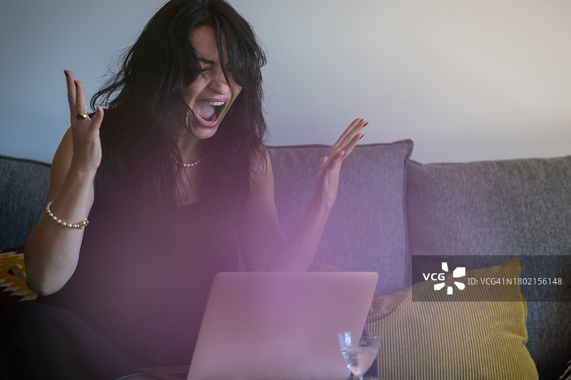 手持相机，在电脑前的女摄影师图片素材