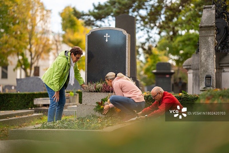 秋季墓地里的人们在坟墓旁工作图片素材