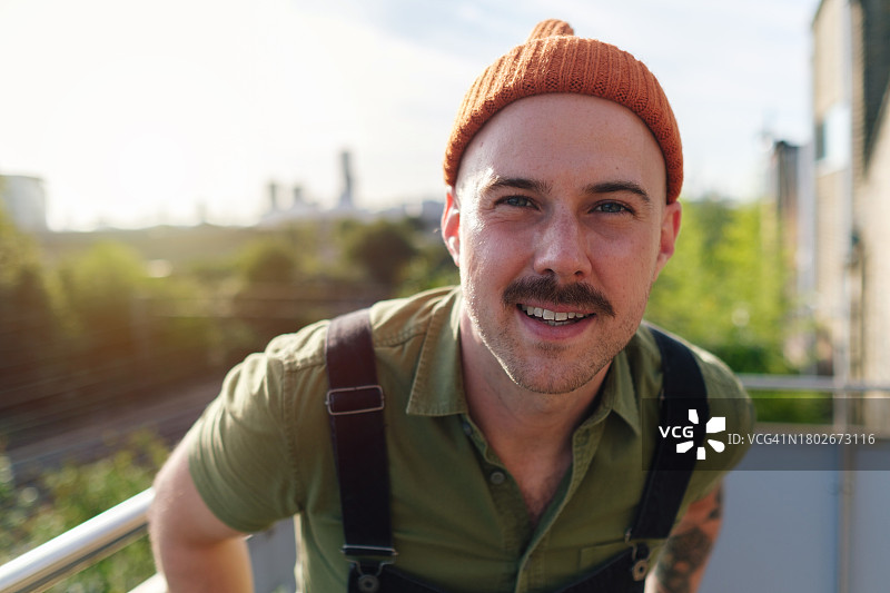 戴着无檐小便帽和胡须的白皮肤男子在森林背景下盯着相机的特写图片素材