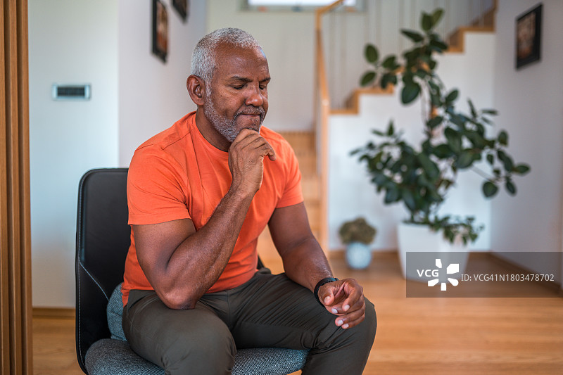 在家中思考心理健康问题的西班牙裔中年男人图片素材