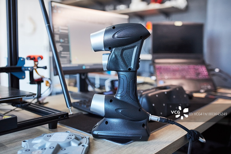 工作台上带工具的3D打印机、便携式激光扫描仪和电脑，适用于设计、高科技或未来主义流程。工程实验室、未来技术开发和LED机器硬件。图片素材
