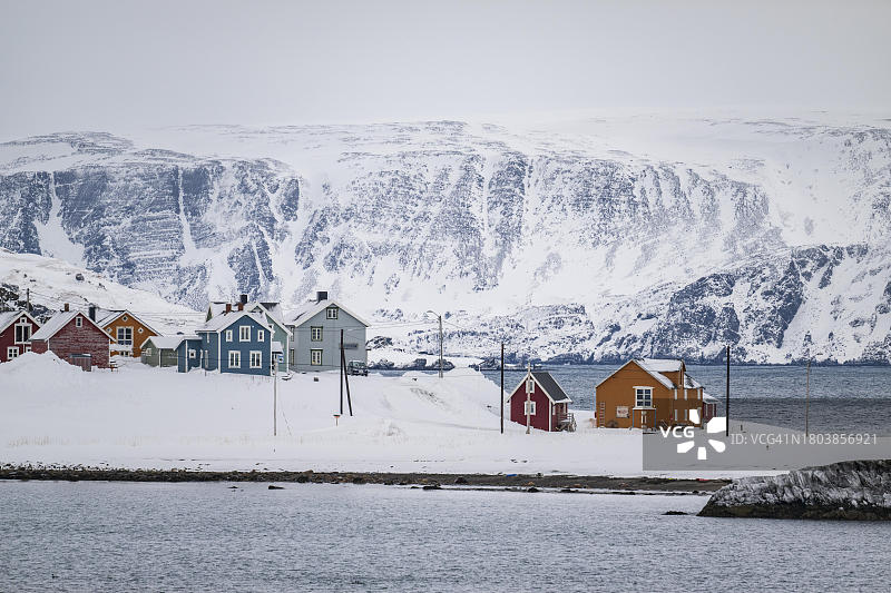 挪威北部芬马克瓦朗厄尔半岛孔斯峡湾渔村的雪景彩色房屋图片素材