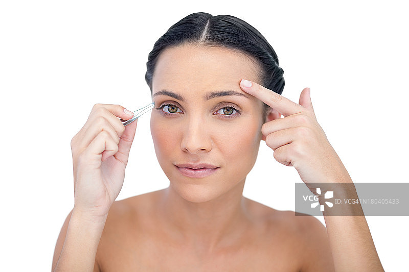 拿着镊子的好奇年轻模特图片素材