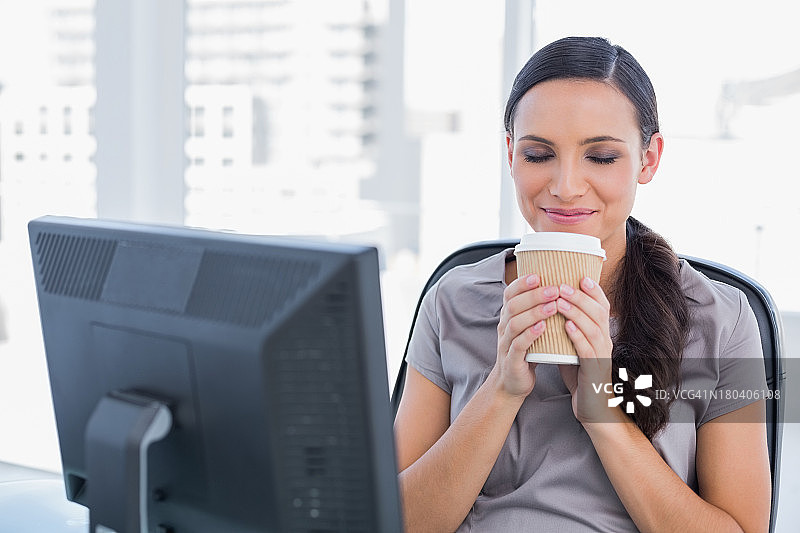 快乐迷人的女商人手 holding 着咖啡图片素材