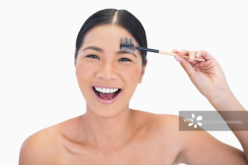 笑容满面的模特正在使用眉刷图片素材
