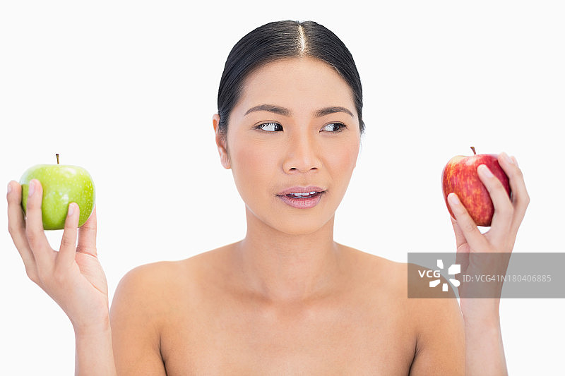 好奇的黑发模特双手拿着苹果图片素材